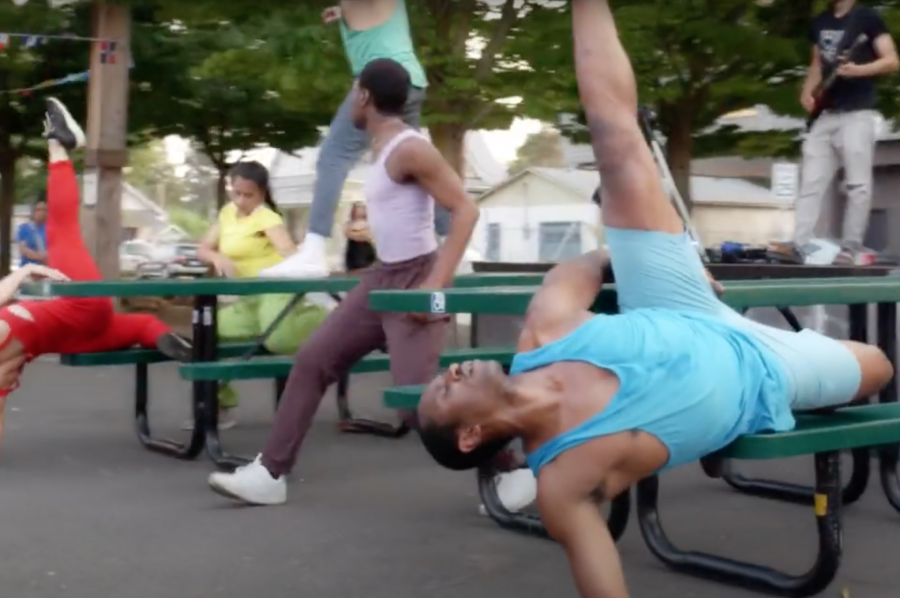 Dancers performing on picnic tables in an outdoor eating area
