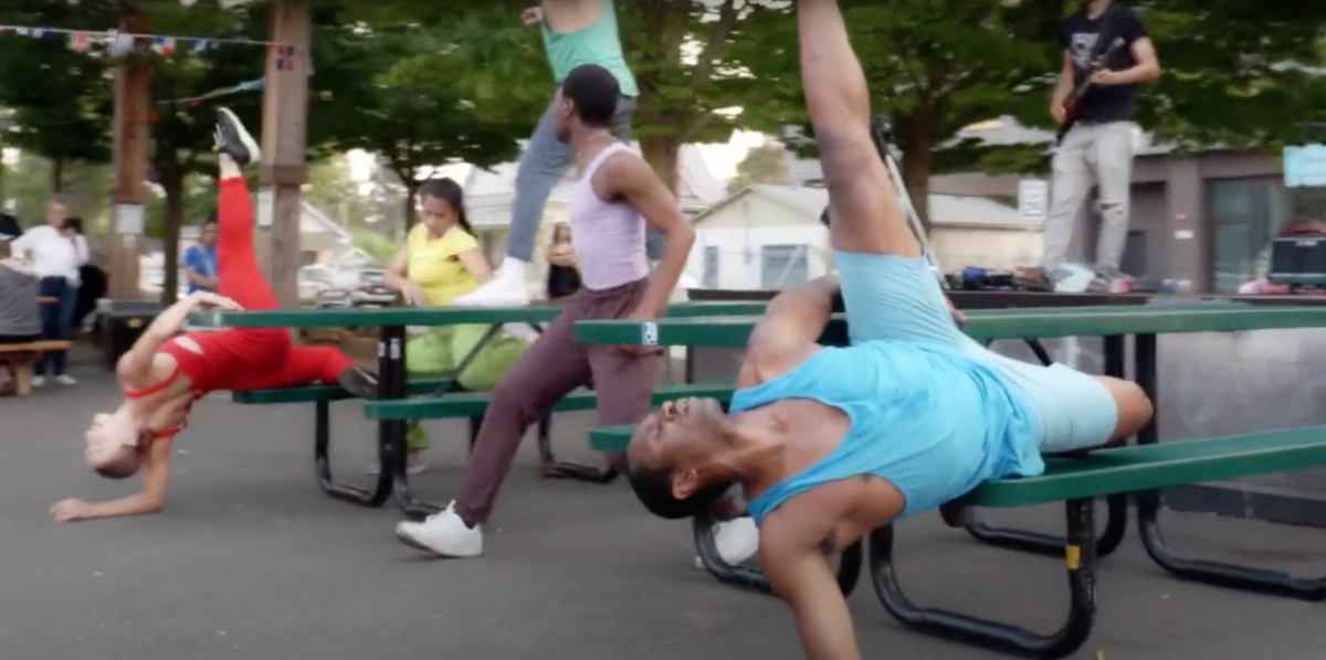 Dancers performing on picnic tables in an outdoor eating area